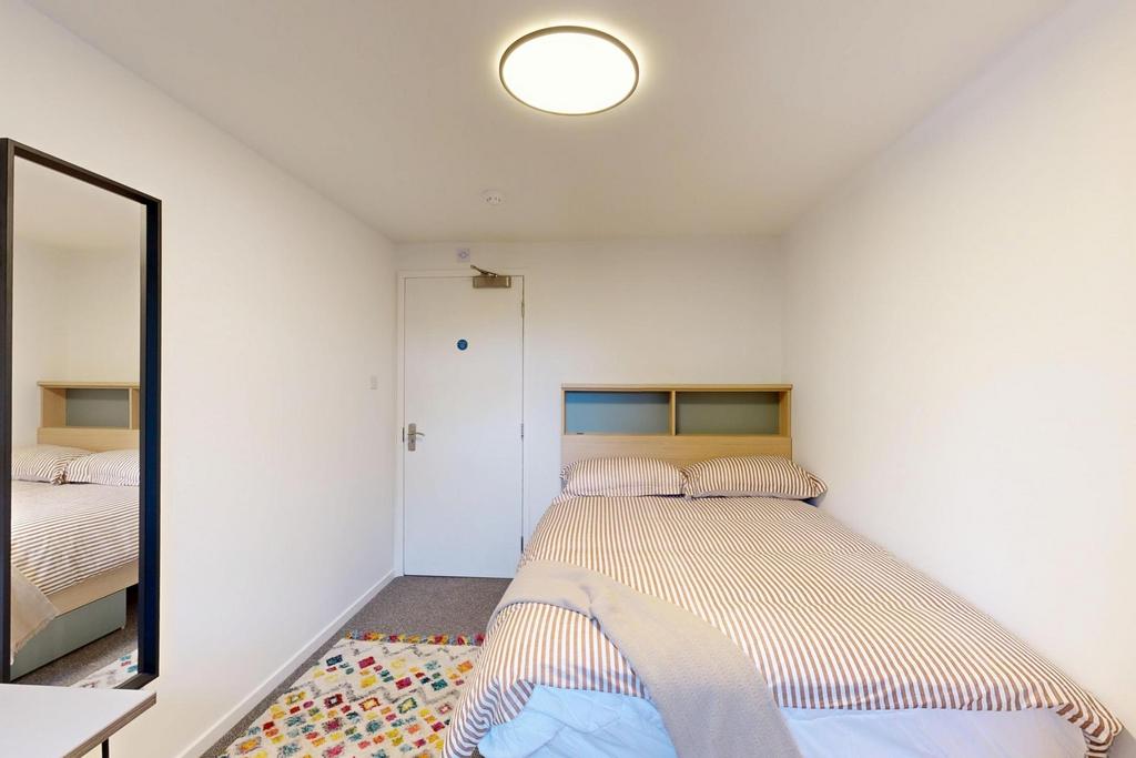Neat, simply furnished double bedroom with a co...