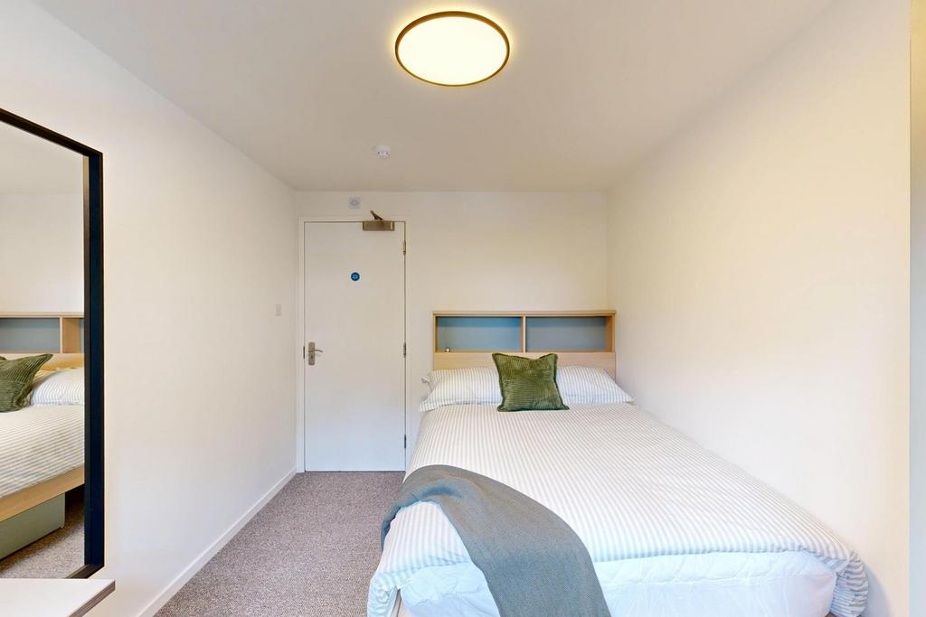 Bright, simply furnished single bedroom with a ...