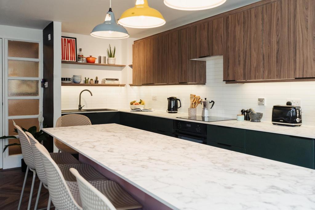 Modern kitchen featuring a spacious white marbl...
