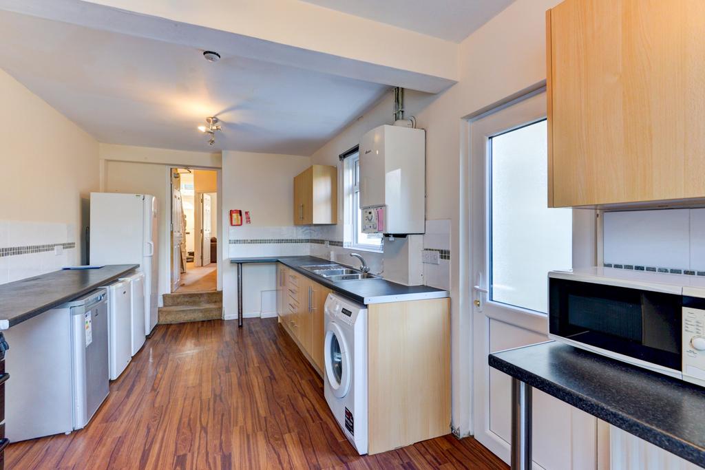 Long galley kitchen with wood-effect flooring, ...