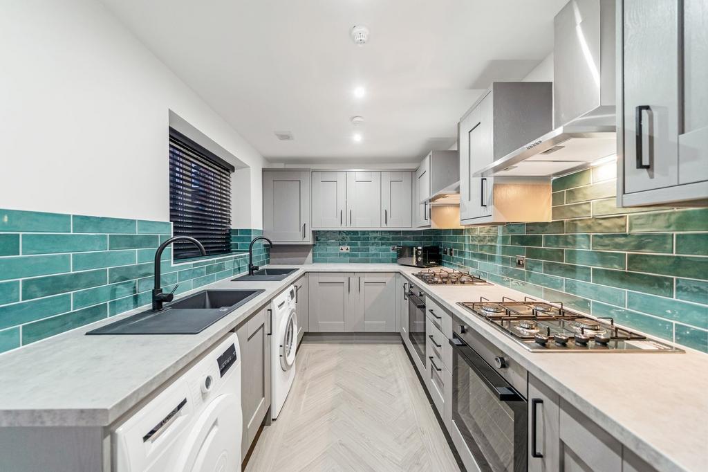 Modern kitchen featuring sleek grey cabinetry, ...