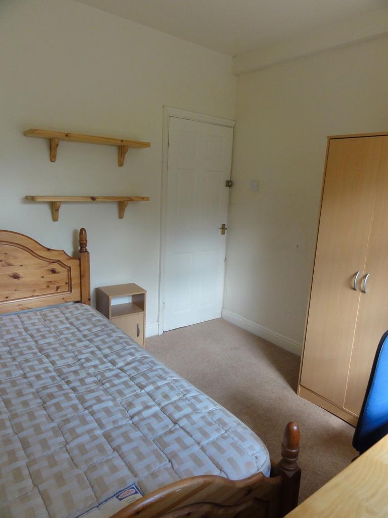 A cozy bedroom featuring a wooden bed frame, a ...