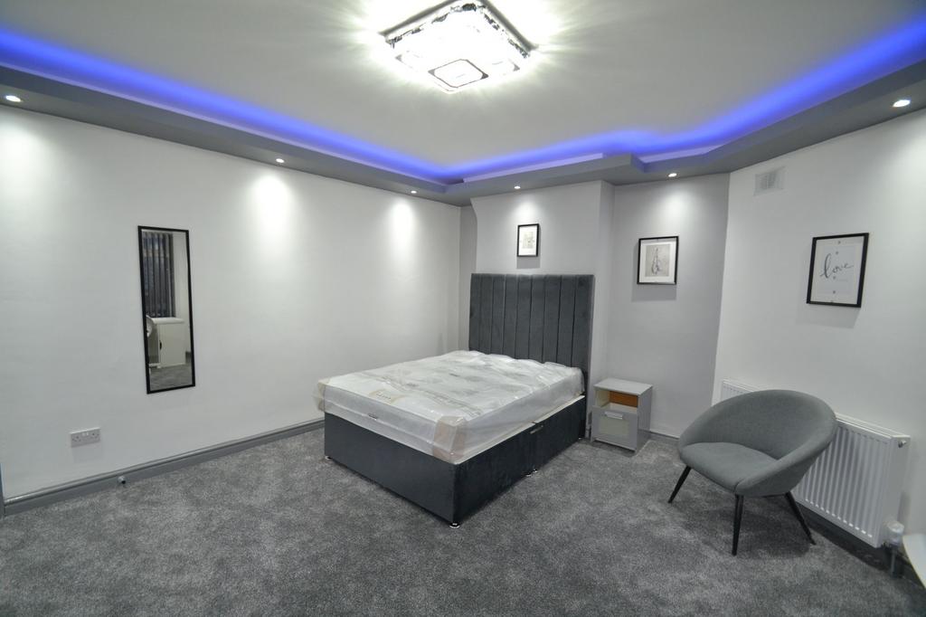 Contemporary double bedroom with a grey upholst...