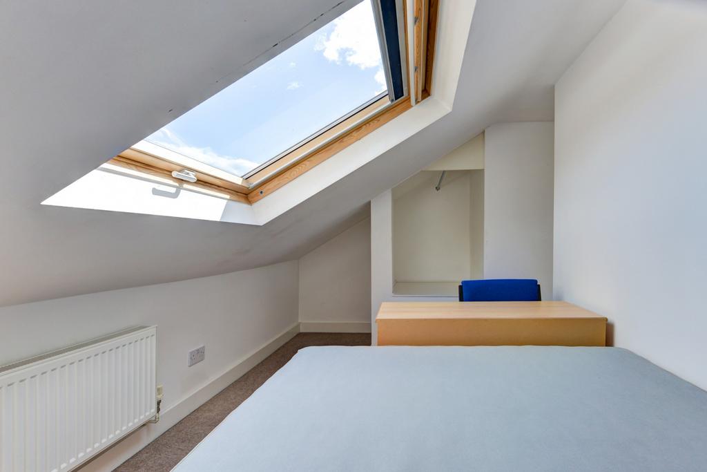 A bright and tidy bedroom featuring a skylight ...