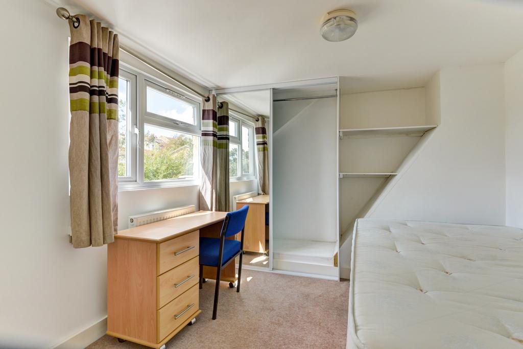 A bright and tidy bedroom with a large window p...