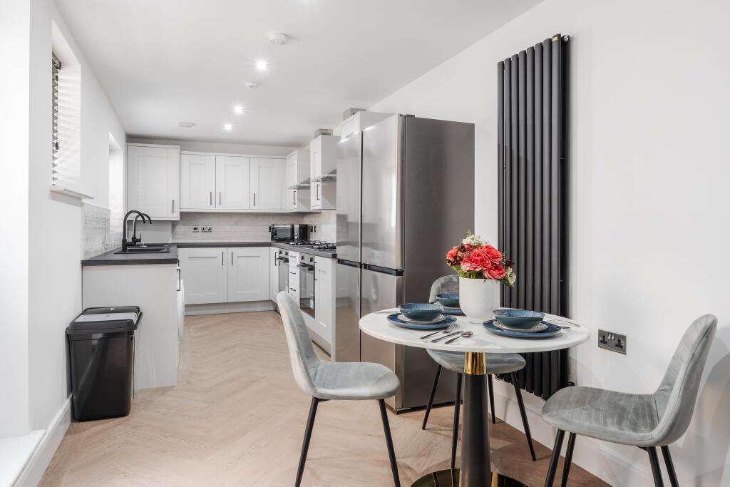 Modern and spacious kitchen with sleek white ca...