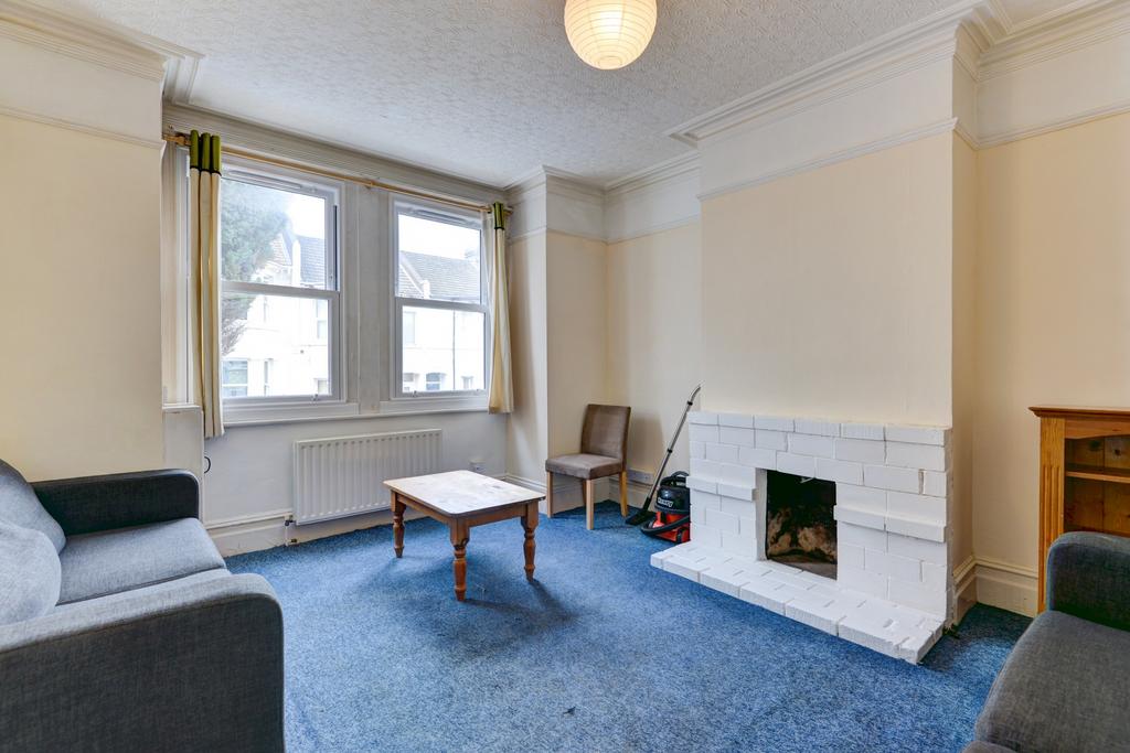 A spacious, well-lit living room with large win...