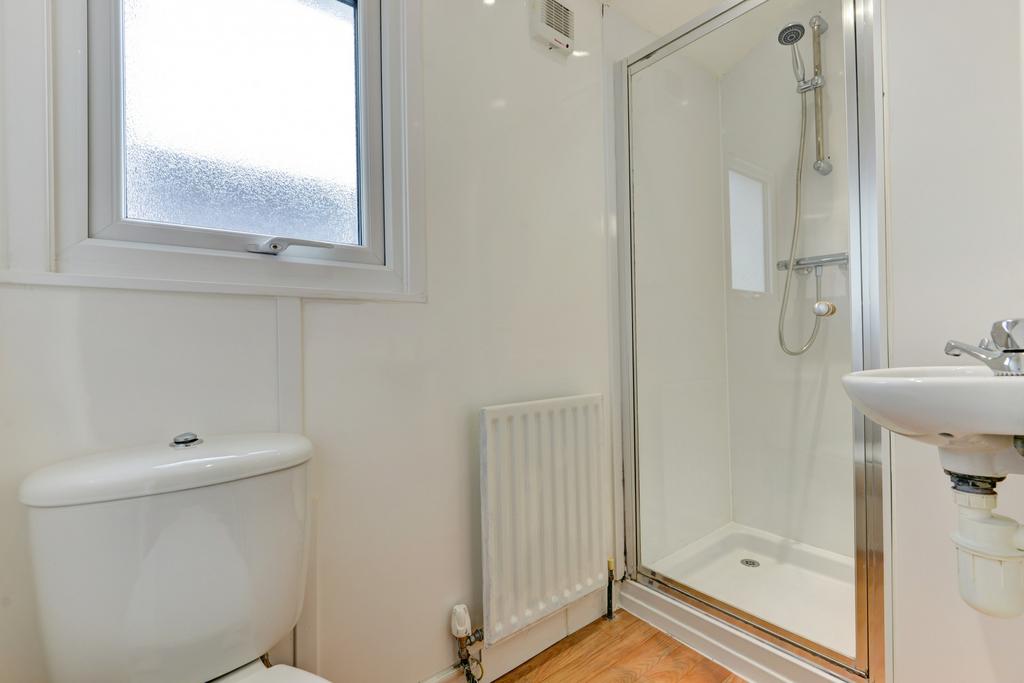 A clean, modern bathroom with a shower enclosur...