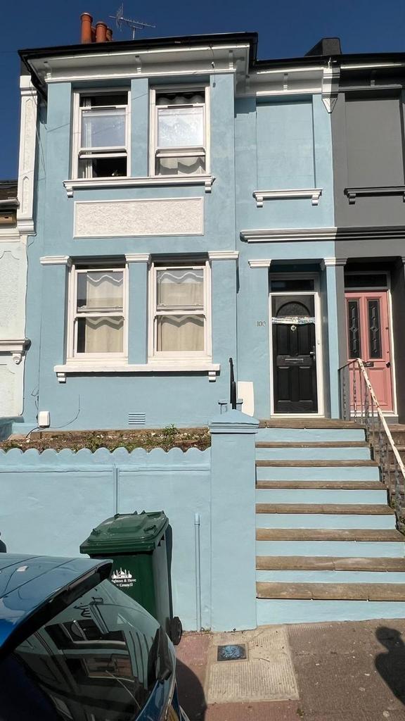 A charming blue terraced house featuring a welc...