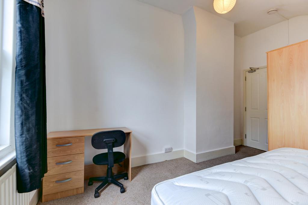 Bright, simply furnished bedroom with a large w...