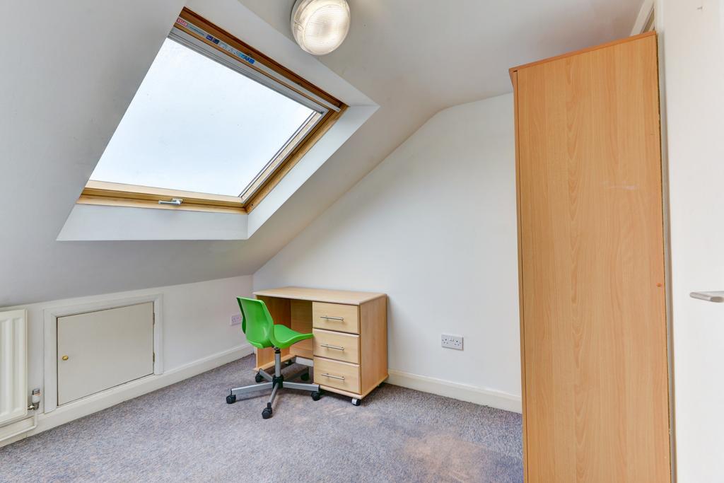 Bright attic single bedroom with a large skylig...