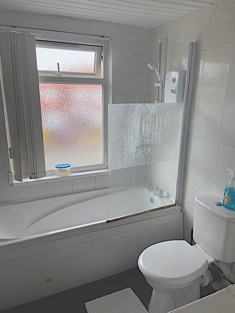 Bright, tidy bathroom with a bathtub and shower...