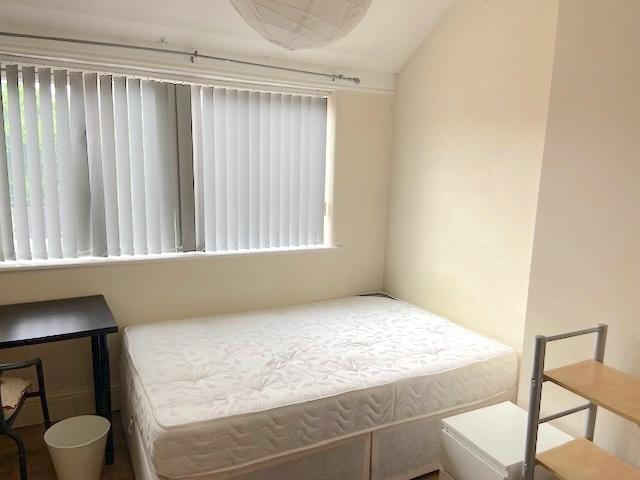 Bright, simply furnished bedroom with a large w...