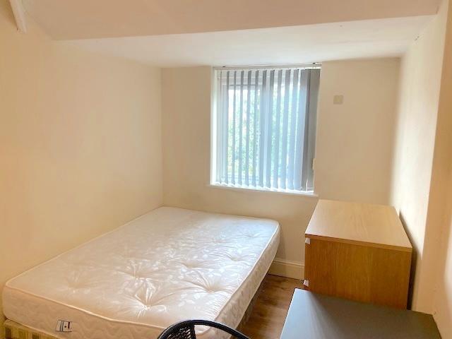 Bright, simply furnished bedroom with a double ...