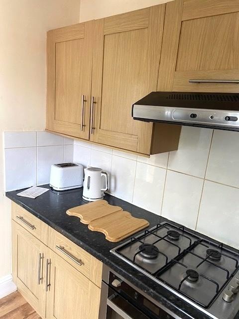 Bright fitted kitchen with light wood cabinets,...
