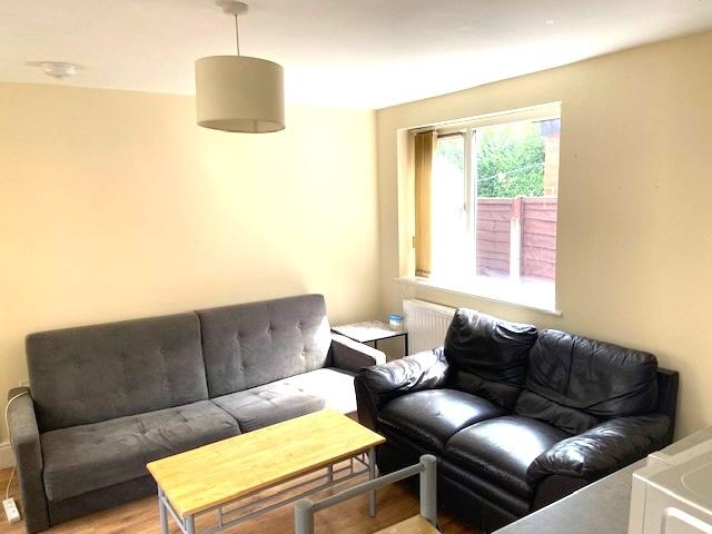 Bright, neatly presented living room with a lar...