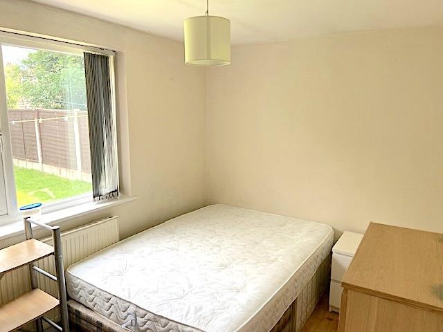 Bright, simply furnished bedroom with a large w...