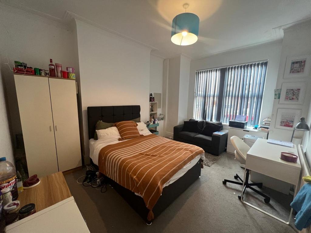 Bright, neatly arranged double bedroom with a c...