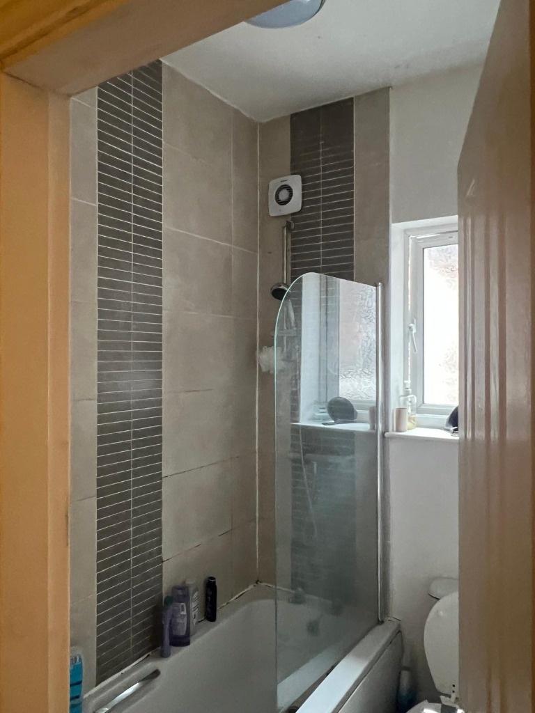 Modern bathroom with a tiled bath and shower co...