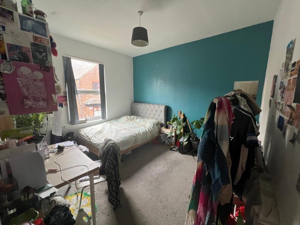 Bright double bedroom with a feature teal accen...