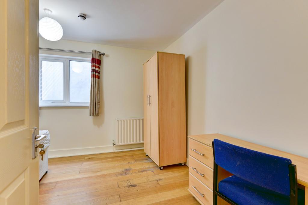 Bright, simply furnished bedroom with wooden fl...