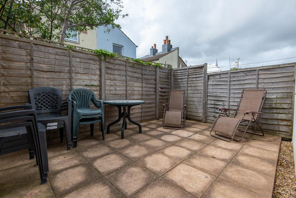 Private paved rear courtyard with seating and r...