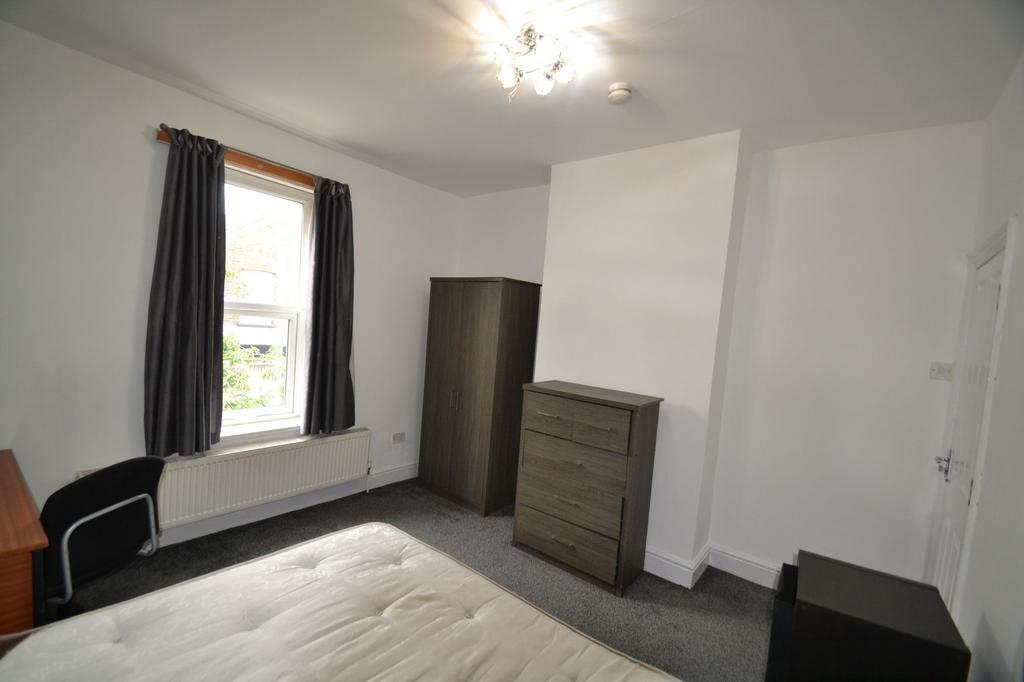 A well-lit double bedroom featuring a comfortab...