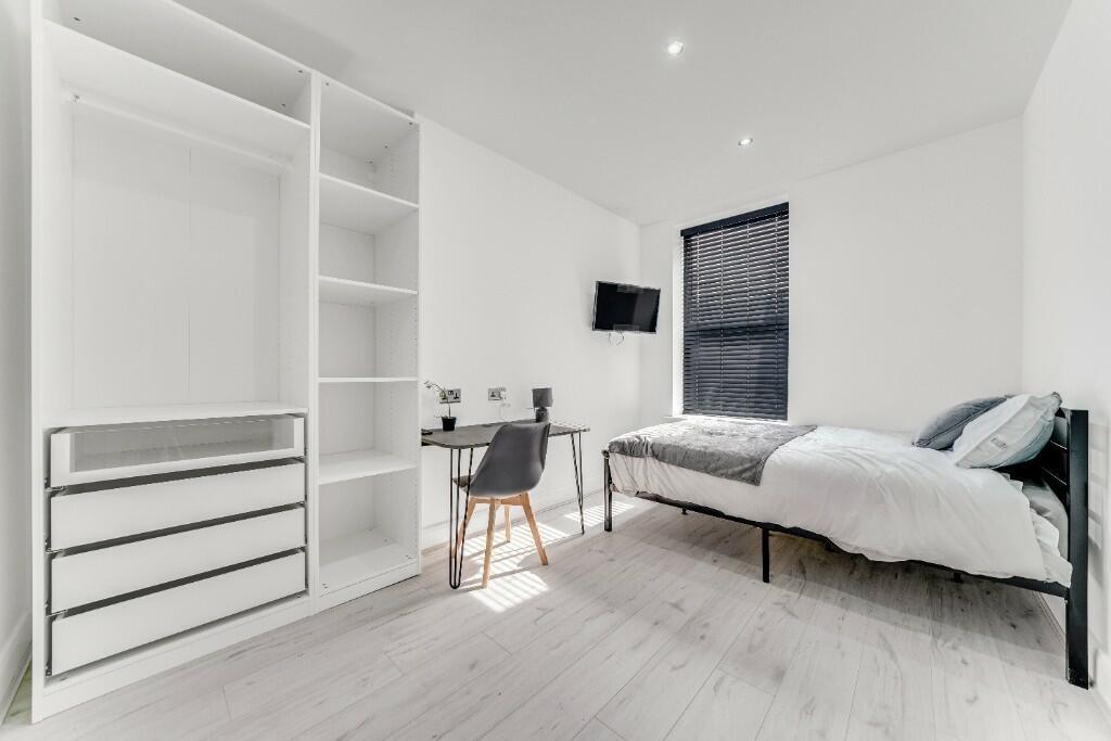 Bright and modern single bedroom featuring a co...
