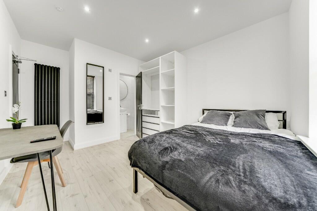 A spacious, modern master bedroom featuring a l...