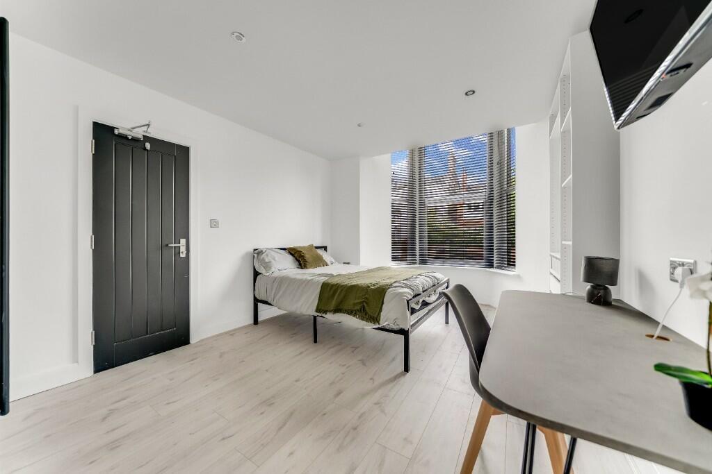 Bright and spacious master bedroom with a comfo...