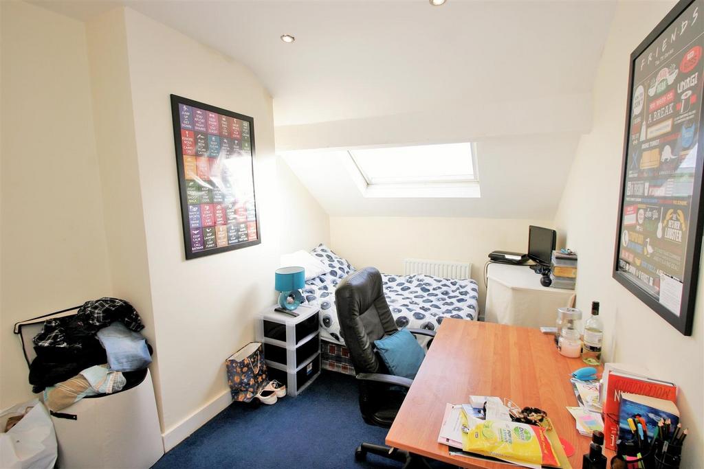 A cozy single bedroom with a sloped ceiling ill...