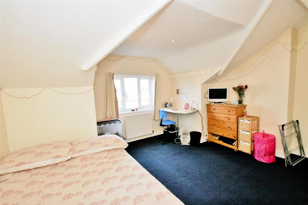 Bright and welcoming bedroom with a cozy bed, a...