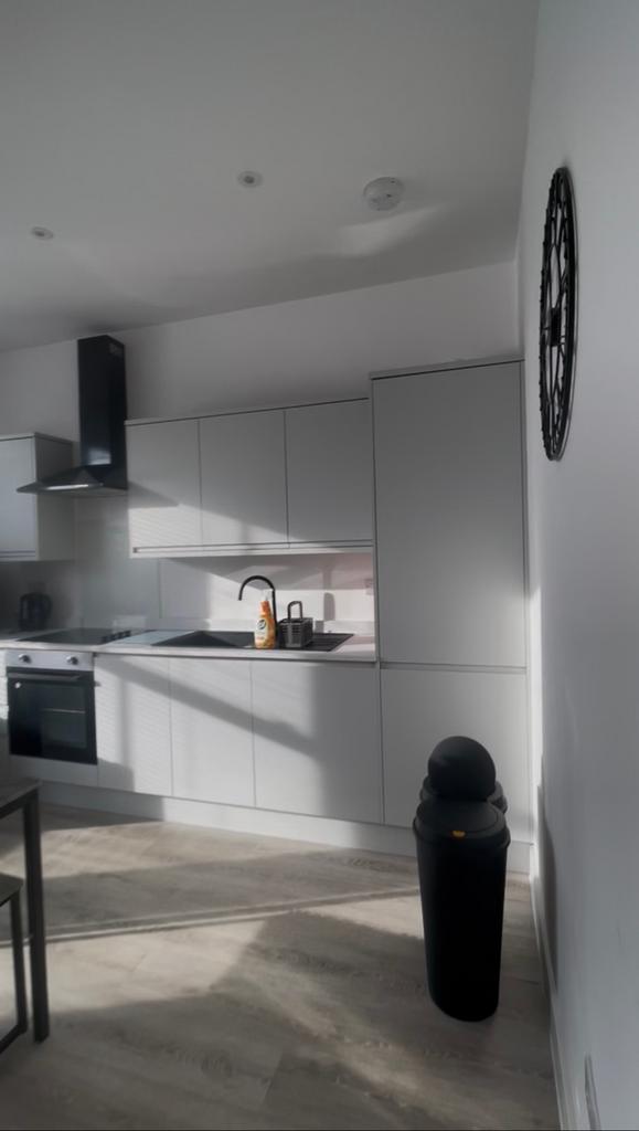 Bright modern kitchen with sleek white cabinetr...