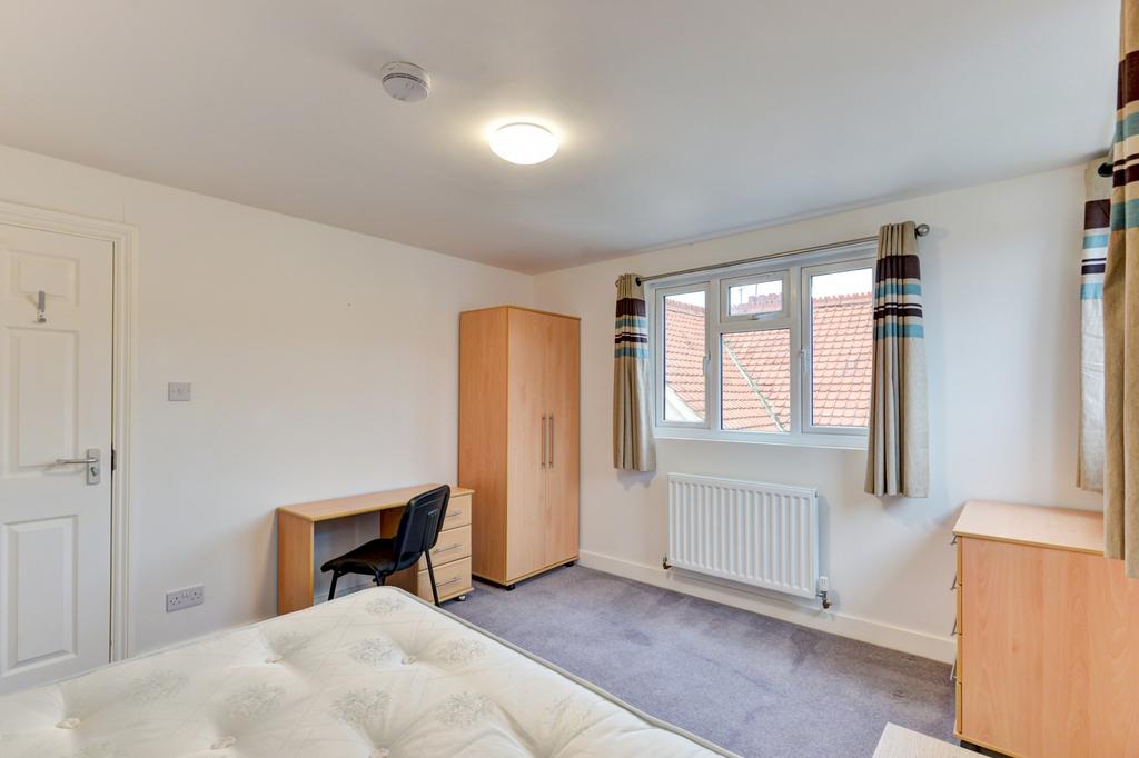 A bright, well-maintained bedroom featuring two...