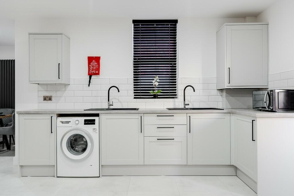 A modern, bright kitchen with sleek white cabin...