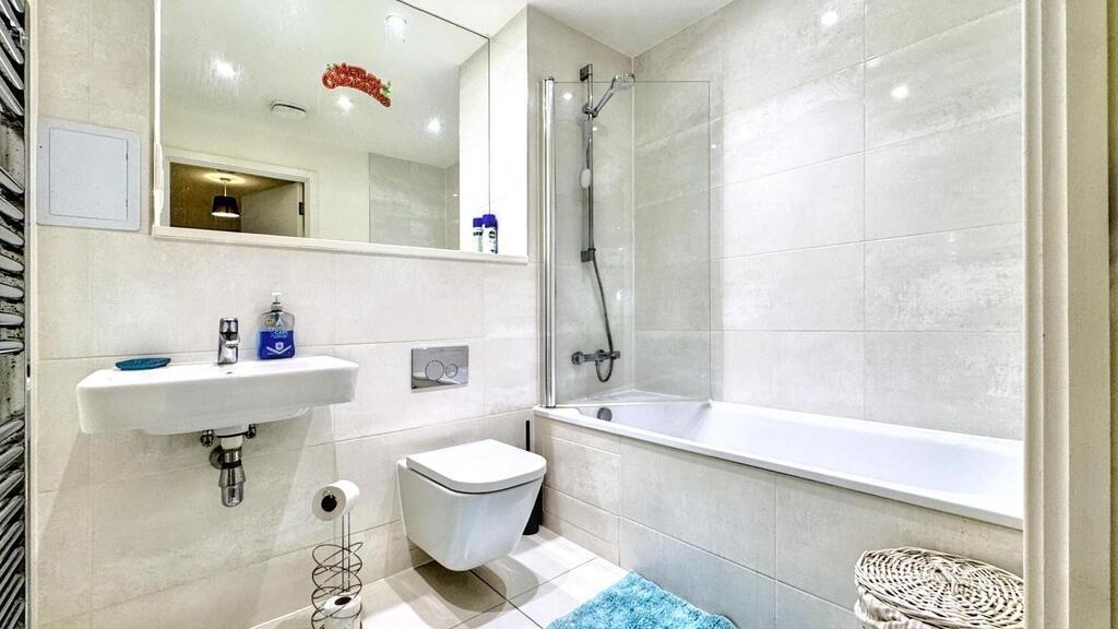 Bright, modern bathroom with a full bathtub and...