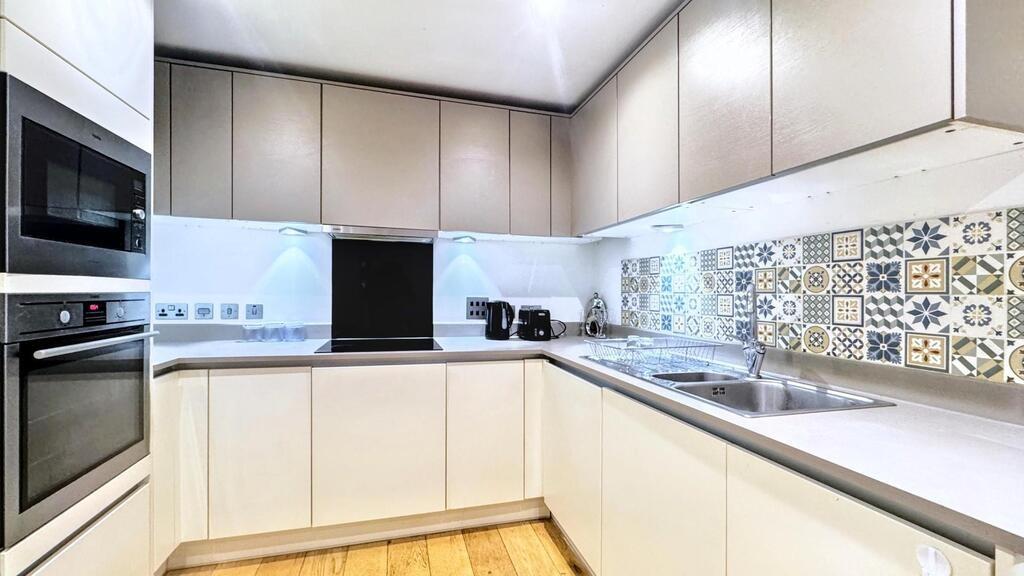Modern fitted kitchen with abundant storage, in...