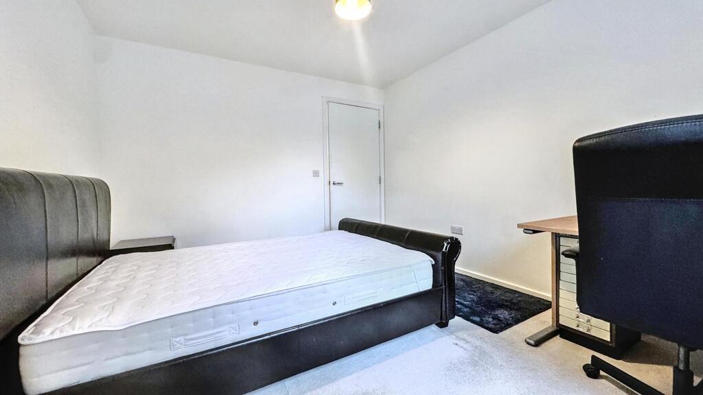 Bright, simply furnished bedroom with a comfort...