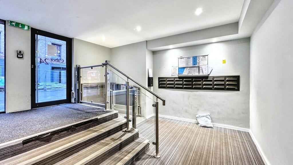 Bright, modern lobby with carpeted floors, a st...