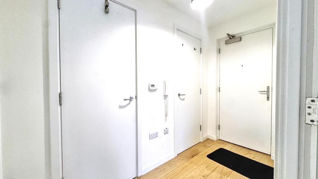 Bright, modern entrance hallway with clean whit...
