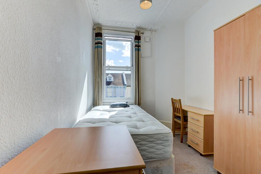 A bright and tidy single bedroom featuring a la...