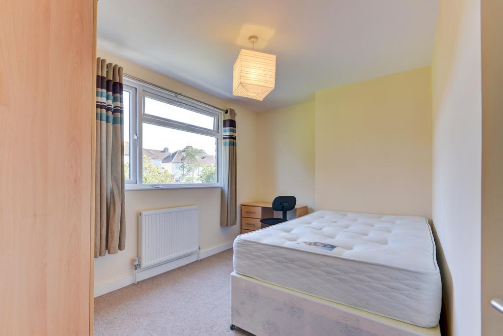 A bright and welcoming bedroom featuring a comf...