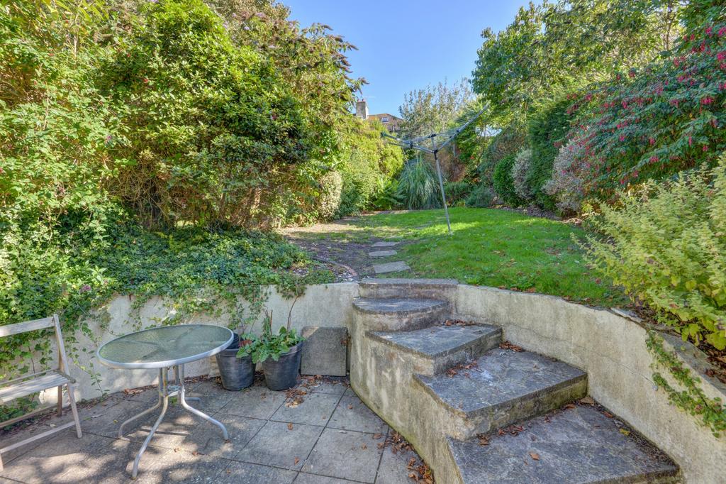 Sunlit private garden with paved patio, raised ...