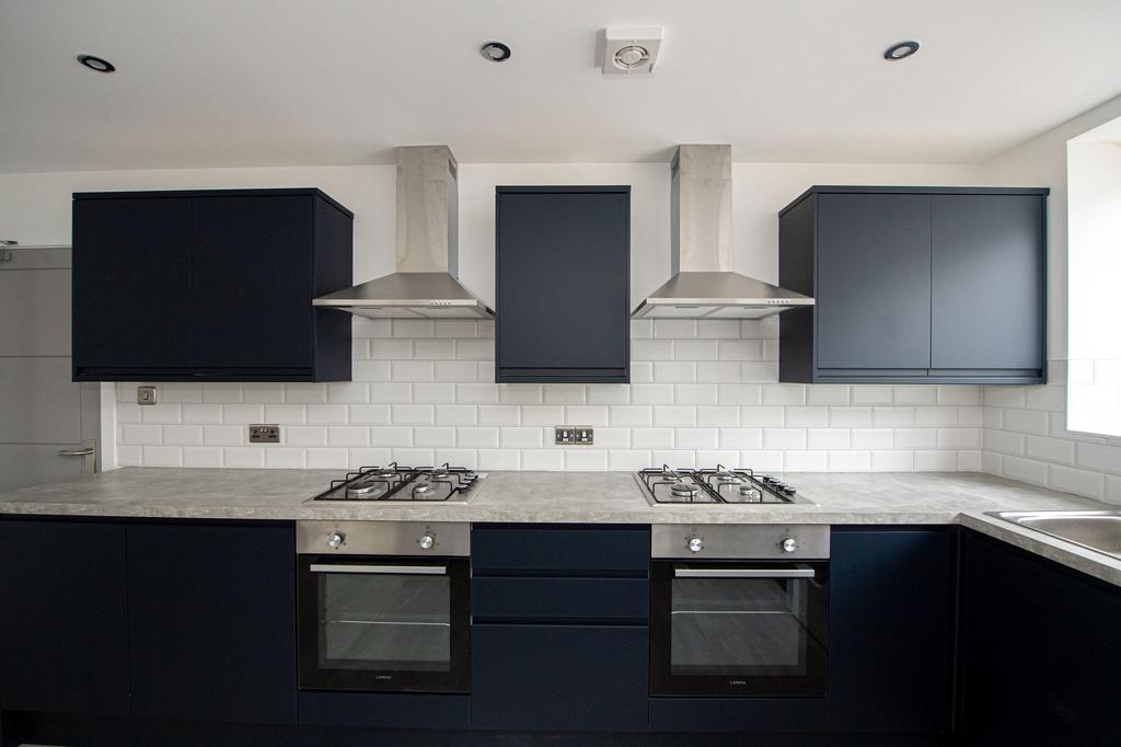 Modern galley kitchen with matching dark cabine...