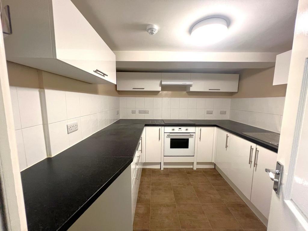 A clean, well-maintained kitchen with white cab...