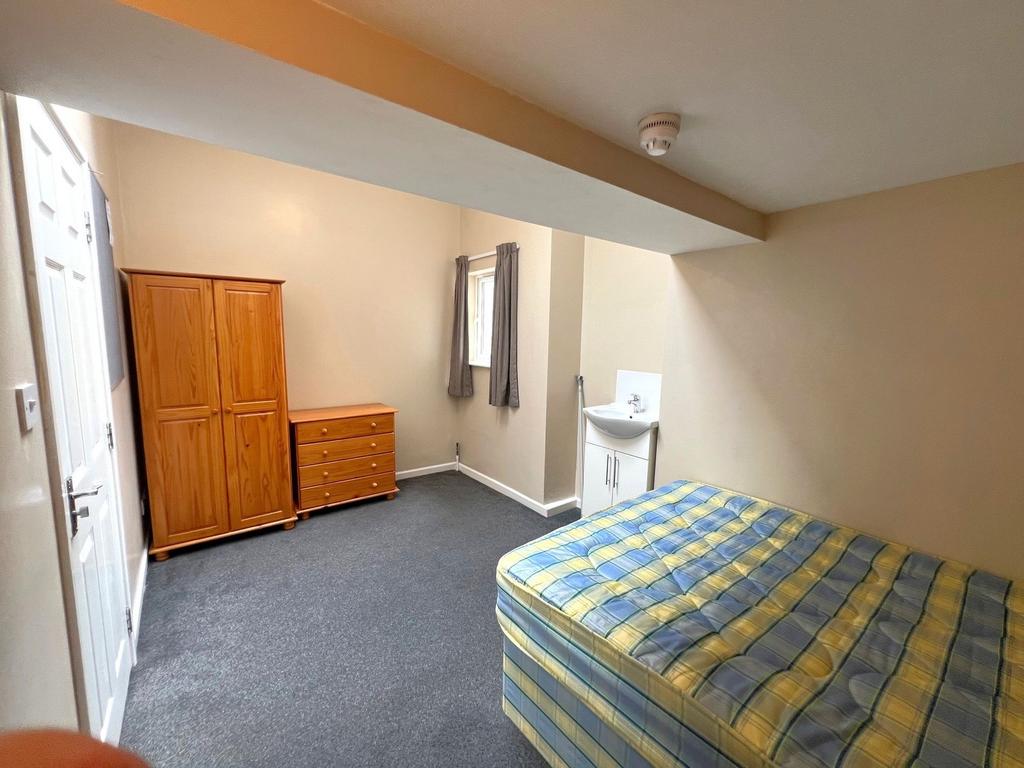 A simple and tidy bedroom featuring a single be...