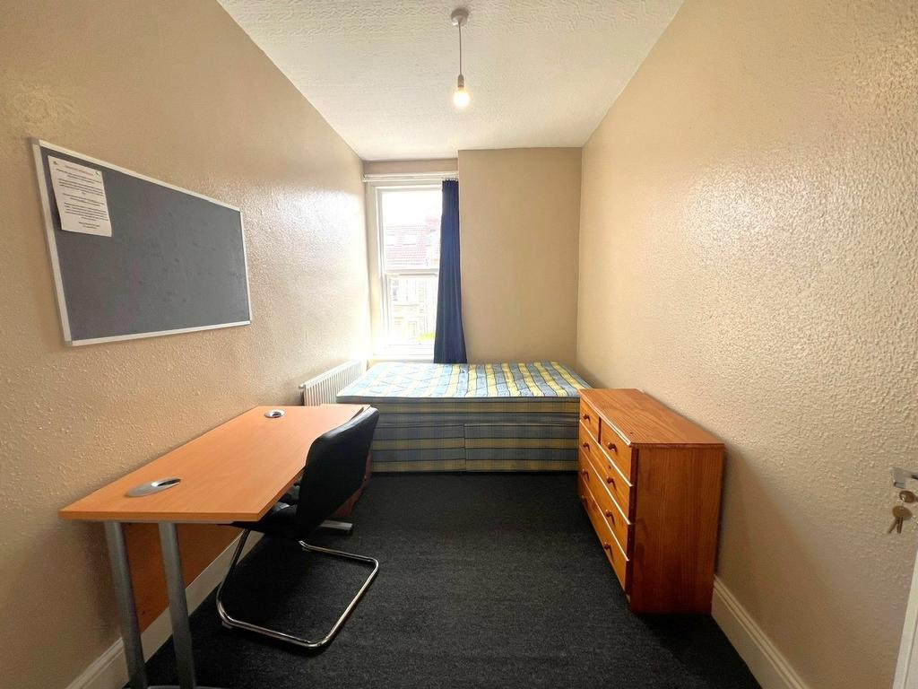Neat single bedroom with a study desk, comforta...