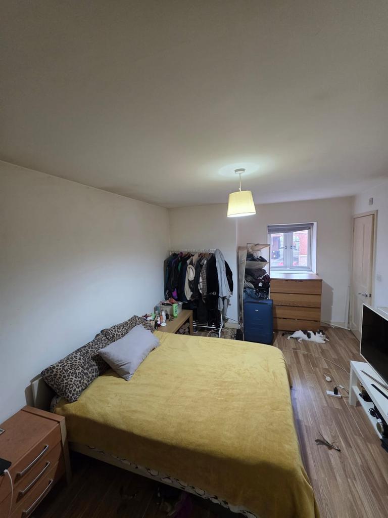 Bright, simply furnished bedroom with a double ...