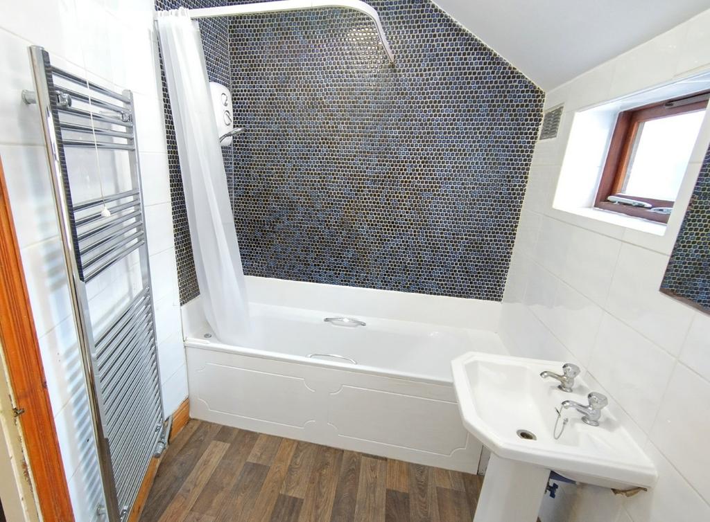 Bright, modern bathroom with a white bathtub an...