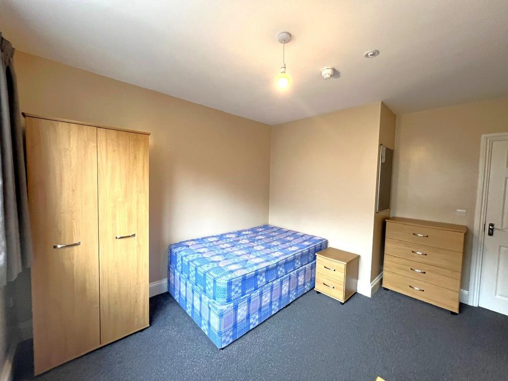 Bright, simply furnished bedroom with a comfort...